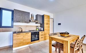 a kitchen with a wooden table with chairs and a tableasteryasteryasteryasteryastery at Atlantic Sal Design Apartments in Santa Maria