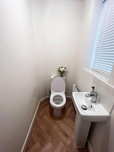 a white bathroom with a toilet and a sink at Beautiful 3-Bed House in Bradford in Bradford