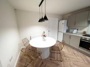 a kitchen with a white table and chairs in a room at 3-Bed House Sleeps 5 Free Parking in Bradford