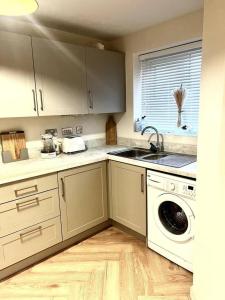 a kitchen with a sink and a washing machine at Beautiful 3-Bed House in Bradford in Bradford