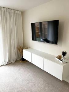 a white cabinet with a television on a wall at Beautiful 3-Bed House in Bradford in Bradford