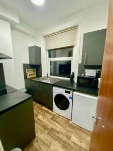 eine Küche mit einer Waschmaschine und einem Geschirrspüler in der Unterkunft Stylish one bed Studio Flat Edgware Road In Central London in London