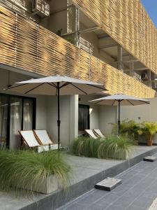 dos sillas y sombrillas frente a un edificio en Suncloud Hotel Koh Samet en Ko Samed