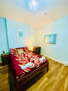 a bedroom with a large bed with a red blanket at Stylish one bed Studio Flat Edgware Road In Central London in London