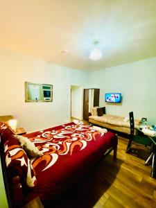 Schlafzimmer mit einem großen roten Bett und einem Schreibtisch in der Unterkunft Stylish one bed Studio Flat Edgware Road In Central London in London