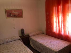 a room with two twin beds and a window at La chimenea de la tía engracia in Ruidera