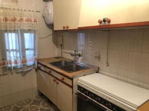 a small kitchen with a sink and a stove at La chimenea de la tía engracia in Ruidera