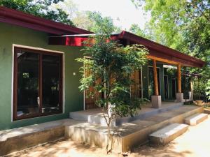 a green house with a tree in front of it at Green Senz - Tourist Board Approved Hotel & Hostel - Sigiriya in Sigiriya