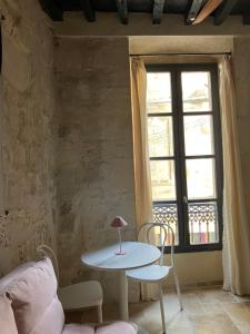 a table and chairs in a room with a window at Pop'Arles in Arles
