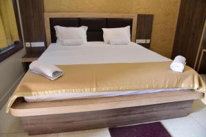 hotel adhunik palace في Keonjhargarh: غرفة نوم بسرير كبير عليها منشفتين