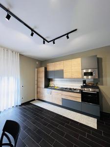 a kitchen with wooden cabinets and a stove top oven at Berlen Home apartment in Torre Maggiore