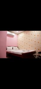 a bed in a room with a pink wall at Hotel Nest Park Street in Kolkata