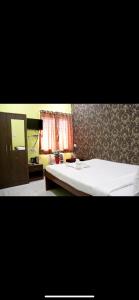 a bedroom with a white bed and a mirror at Hotel Nest Park Street in Kolkata