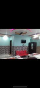 a living room with a red couch and a ceiling fan at Hotel Nest Park Street in Kolkata