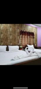 a bedroom with a bed with white sheets and a window at Hotel Nest Park Street in Kolkata