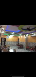 a room with tables and chairs and a ceiling at Hotel Nest Park Street in Kolkata