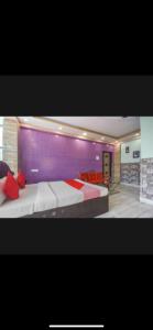 a bedroom with a large bed and a purple wall at Hotel Nest Park Street in Kolkata