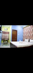 a room with two beds and a chair in it at Hotel Nest Park Street in Kolkata