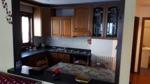 a kitchen with wooden cabinets and a table in it at Bilocale Piano Terra Villetta - La Thuile Frazione Buic in La Thuile