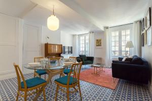 - un salon avec une table, des chaises et un canapé dans l'établissement Strada - magnifique appartement proche Opéra, à Lyon