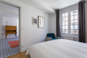 ein Schlafzimmer mit einem weißen Bett und einem Fenster in der Unterkunft Strada - magnifique appartement proche Opéra in Lyon