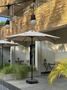 a patio with two white umbrellas in a building at Suncloud Hotel Koh Samet in Ko Samed
