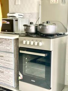 - une cuisinière avec 2 casseroles dans la cuisine dans l'établissement Xellent Suites- Marg House, à Nakuru