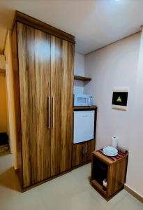un gran armario de madera en una habitación con microondas en Flat Particular - próx Assembleia Leg MT, en Cuiabá