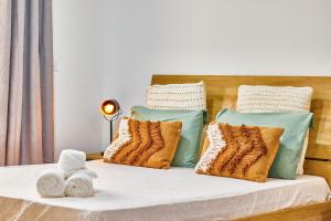 Una cama con almohadas y toallas. en Atlantic Sal Design Apartments en Santa María
