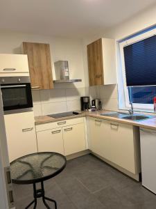 a small kitchen with a table and a chair in it at Pension Imhof in Oyten