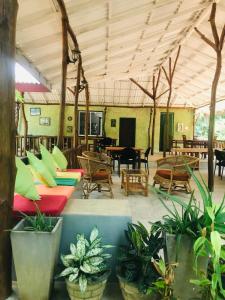 a large room with couches and tables and plants at GreenSenz Resort & Hostel-Sigiriya in Sigiriya