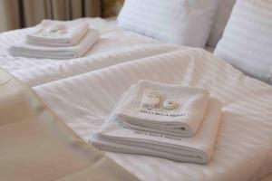 three white towels sitting on top of two beds at Villa Mala Praha Experience in the Center of Žilina in Žilina