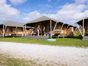 Glamping Lodge في Westerland: رجل يقف داخل خيمة كبيرة