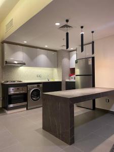 a kitchen with a counter top and a refrigerator at Unique Apart Boulevard Damac Tc2 in Ash Shumaysānī