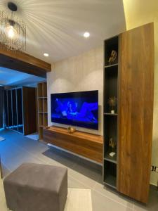 a living room with a large flat screen tv at Unique Apart Boulevard Damac Tc2 in Ash Shumaysānī