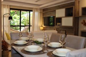 Local 301 Apartment في ريو دي جانيرو: غرفة طعام مع طاولة مع الأطباق وكؤوس النبيذ