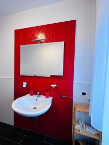 a bathroom with a red wall with a sink at Berlen Home apartment in Torre Maggiore