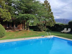 a large blue swimming pool in front of a house at El Rincon del Tejo in Herreros
