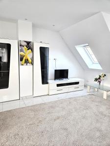 a white living room with a tv and a couch at Schneider Apartments in Neustadt am Rübenberge