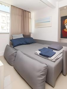 Conforto e Estilo • 3 Quartos em Copacabana في ريو دي جانيرو: سرير عليه وسائد زرقاء في غرفة