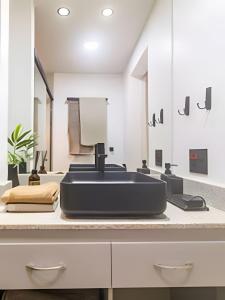 Conforto e Estilo • 3 Quartos em Copacabana في ريو دي جانيرو: حمام مع حوض أسود ومرآة