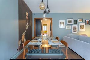 a dining room with a table and a couch at Stella - 2 chambres-balcon- place de la République in Lyon