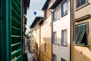 a blue balloon flying over an alley with buildings at Casa nel Centro Storico Firenze in Florence