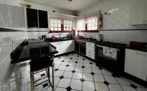 uma cozinha com pisos e electrodomésticos em azulejo preto e branco em Chácara Campo Verde em Bragança Paulista