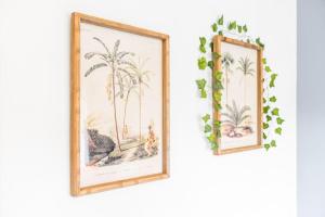 two framed pictures of palm trees on a wall at The Home on The Hill in Birmingham