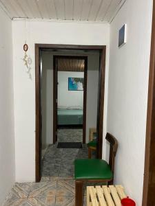 a hallway with a room with a bed and a chair at Vilarejo hospedagem in Ilha do Mel