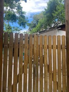 una valla de madera frente a una casa en Vilarejo hospedagem en Ilha do Mel