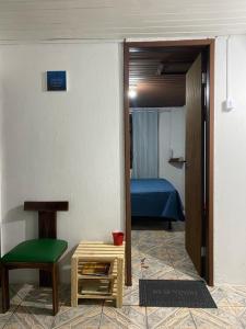Pokój z pokojem z łóżkiem i krzesłem w obiekcie Vilarejo hospedagem w mieście Ilha do Mel