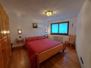 a bedroom with a red bed and a window at Maison Sarteur Alloggio ad uso turistico -VDA-LA THUILE- 0065 in La Thuile +39 photos