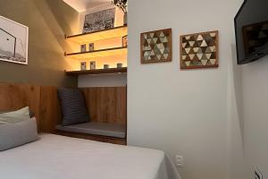 a bedroom with a bed and a couch and a tv at Apto Luxuoso, 50 Mts da Praia em Copacabana para 6 in Rio de Janeiro